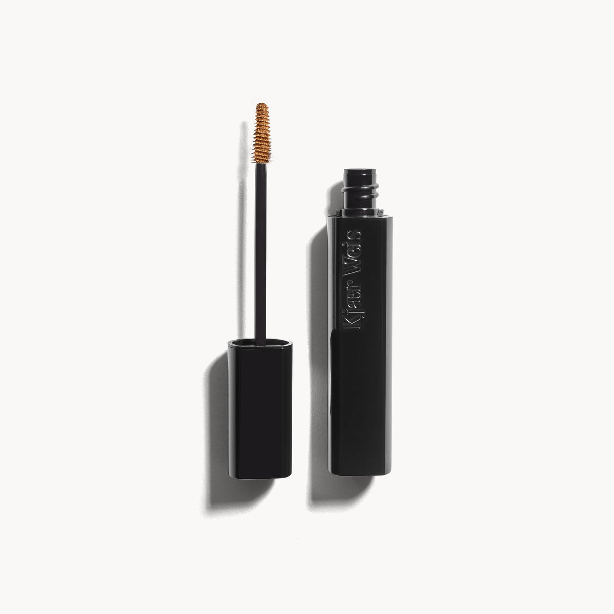 Kjaer Weis The Brow Gel in Blonde, shown open with its precise, slimline brush applicator on an off-white background.