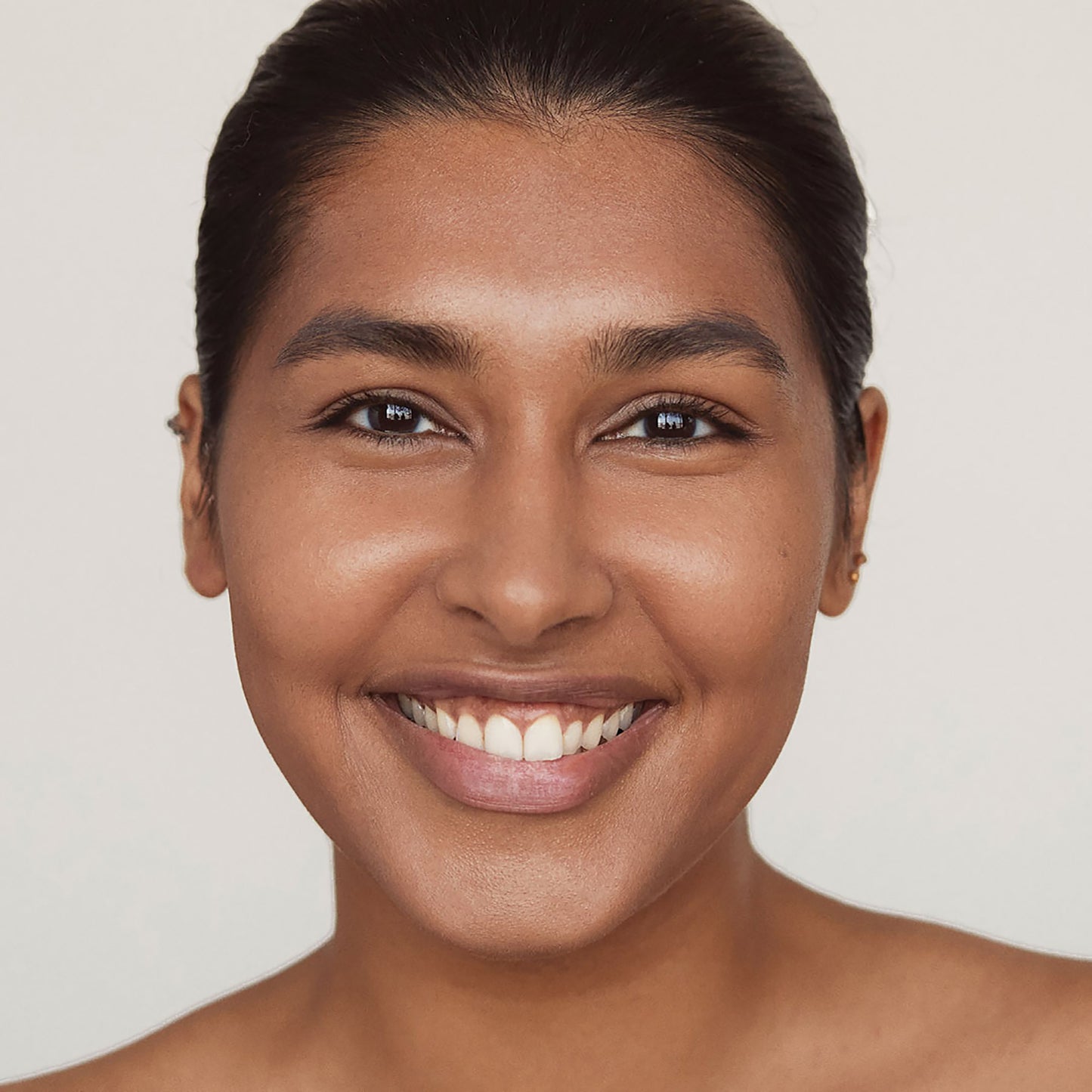 Close up of a person’s face with cool-toned tan skin