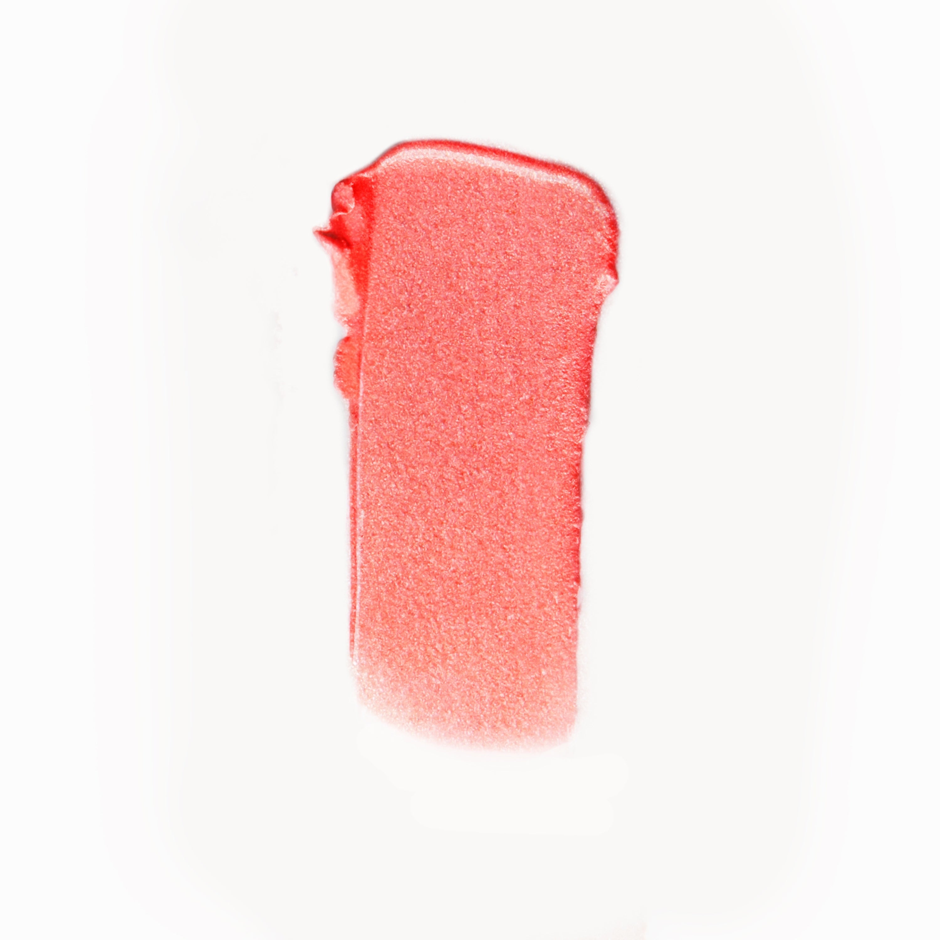 A wipe of deep coral cream blush on a white background