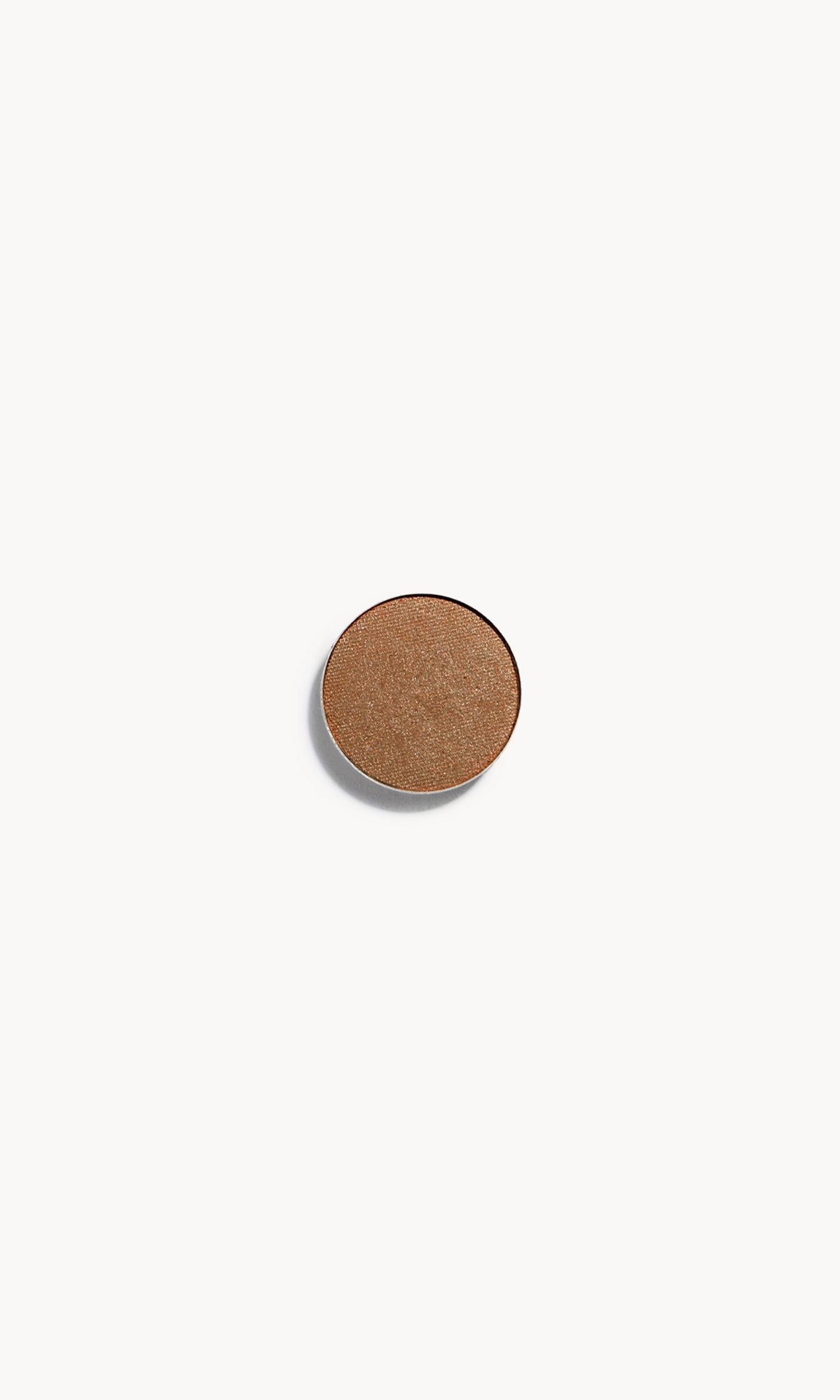 A circle of brown-gold eye shadow on a white background