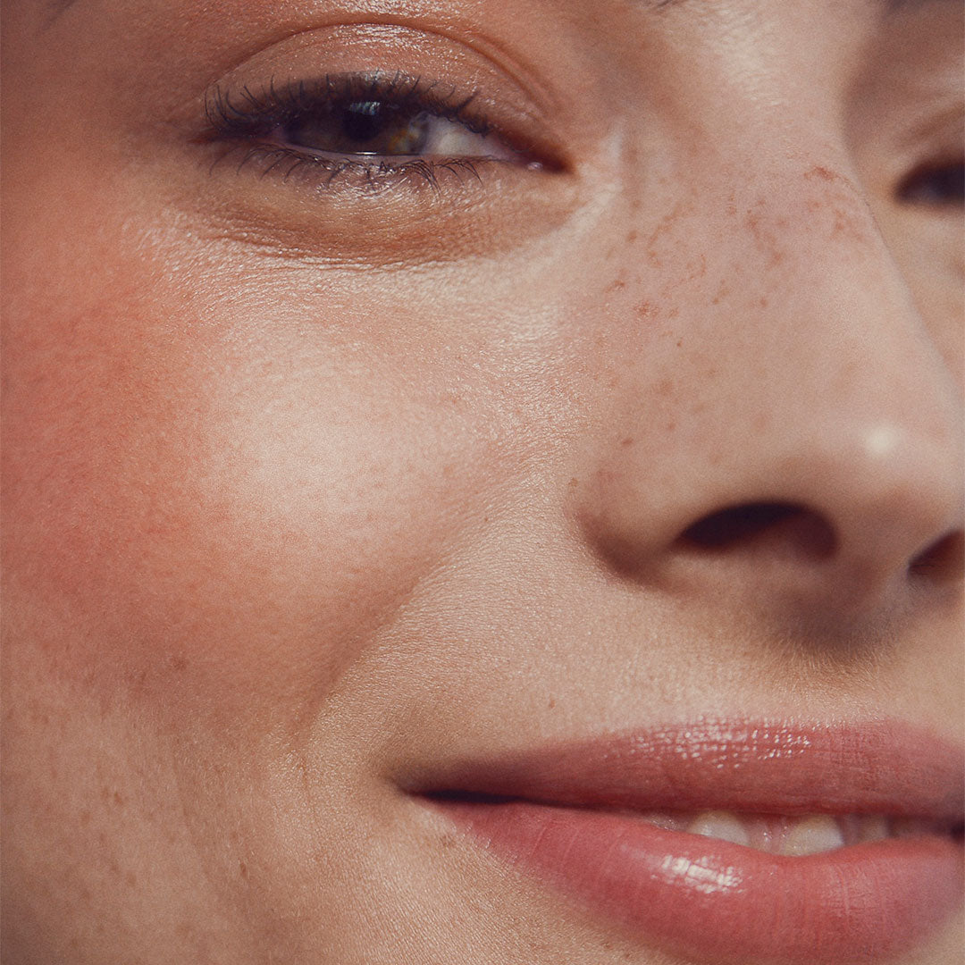 Close up of a person’s face with a fair skin tone wearing cream blush
