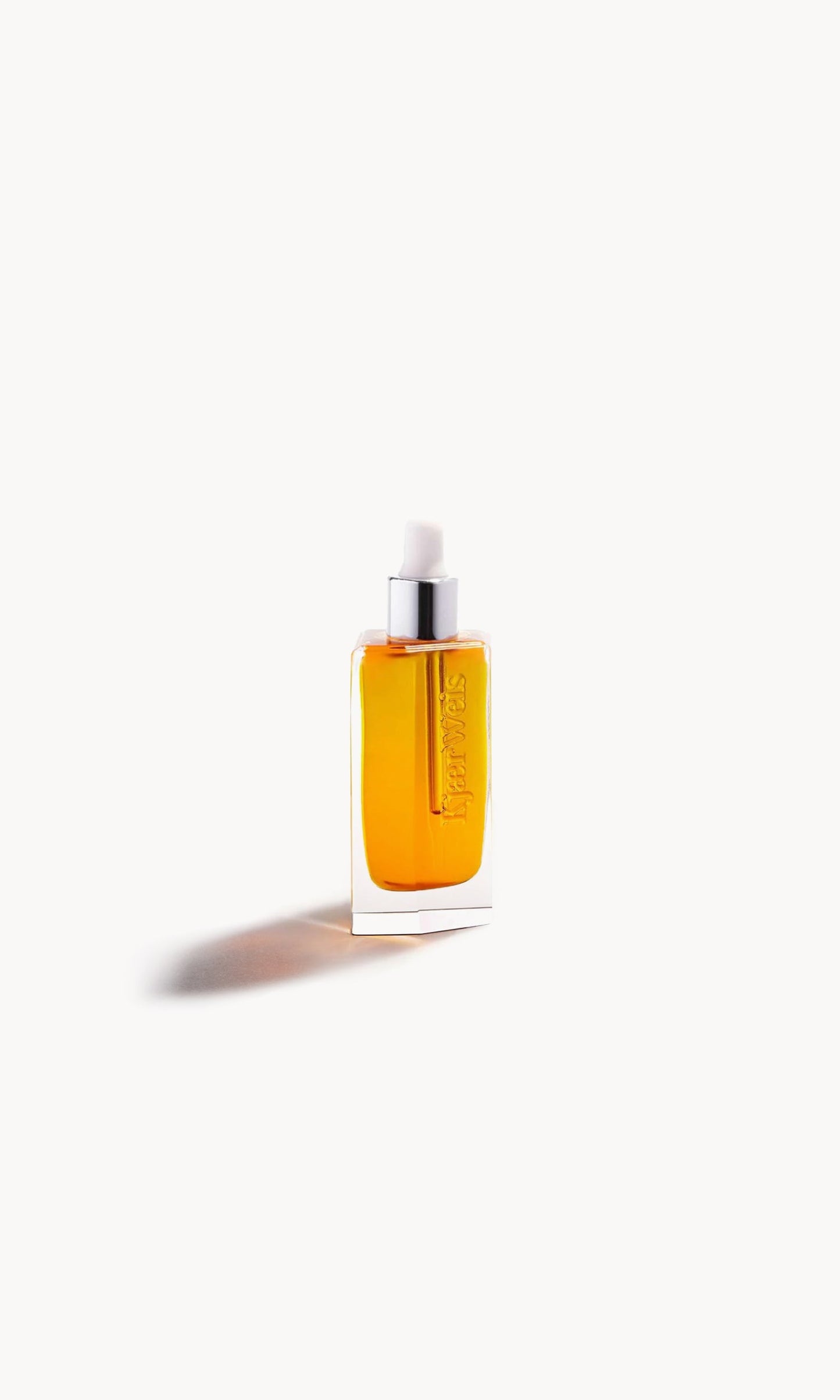 Glass bottle with white pipette top and gold-coloured liquid inside on a white background