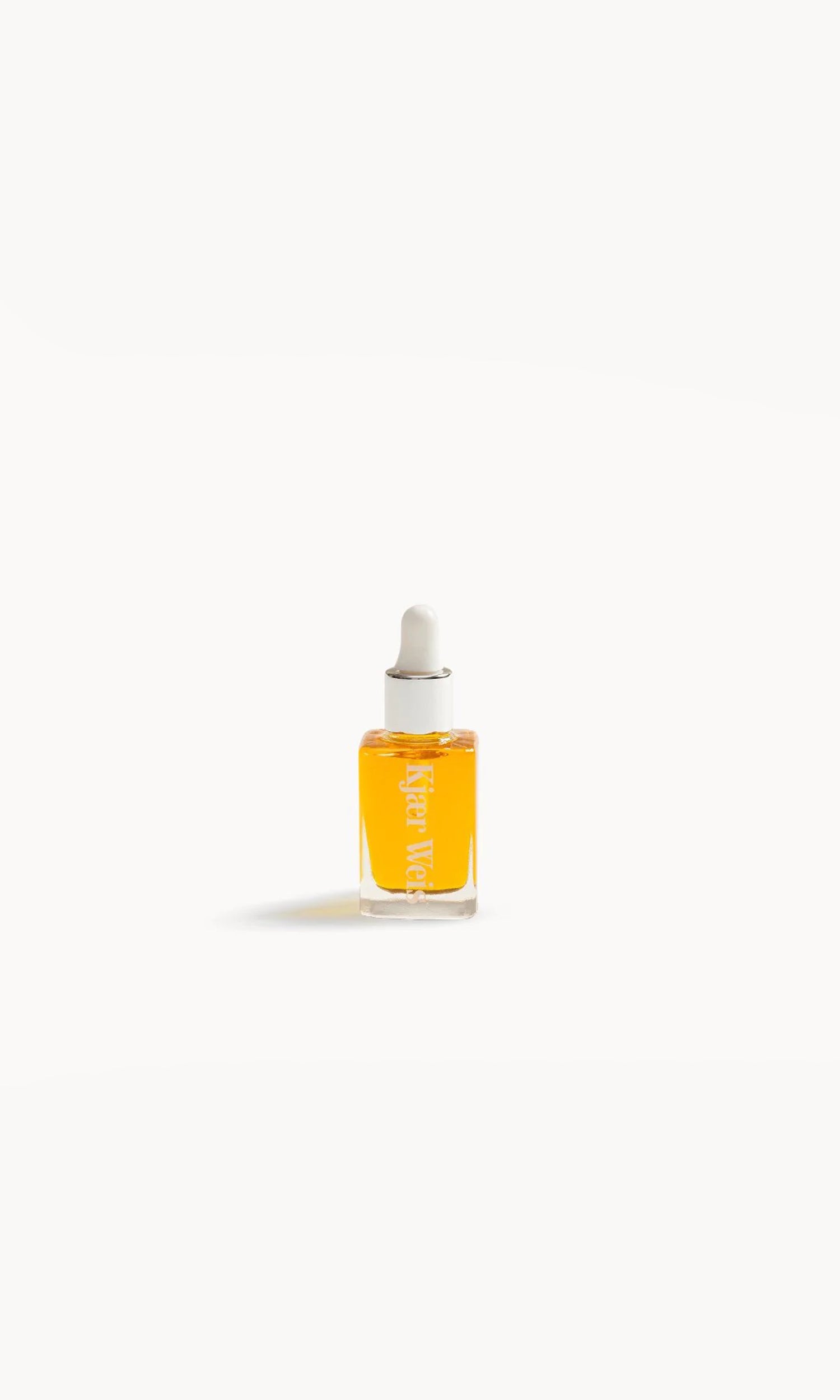 small glass bottle with a white pipette lid and gold-coloured liquid inside on a white background