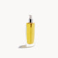 Kjaer Weis body oil in glass bottle with cap removed, showing a white pump