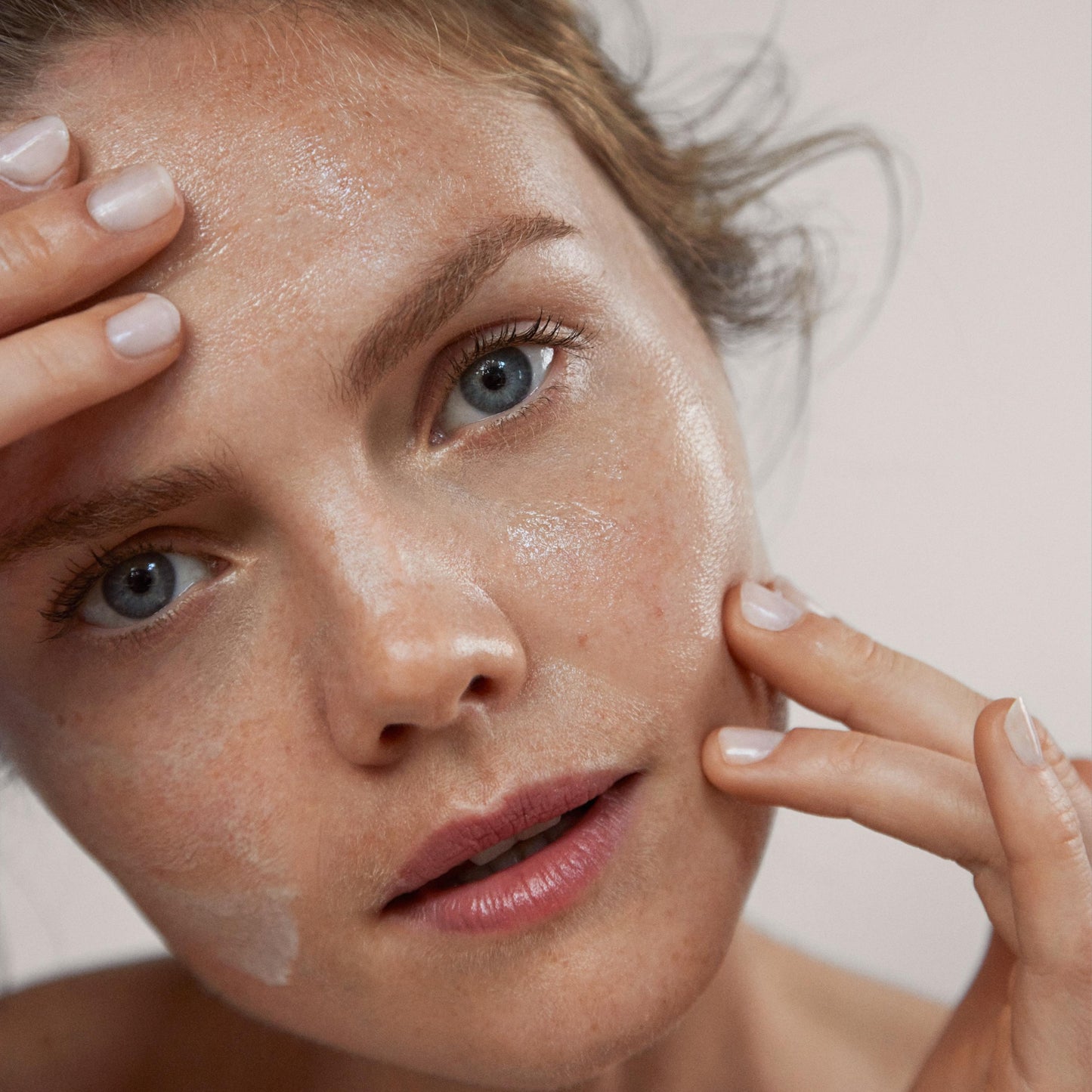 Close up of a person’s face with a layer of sheer cleanser on the skin