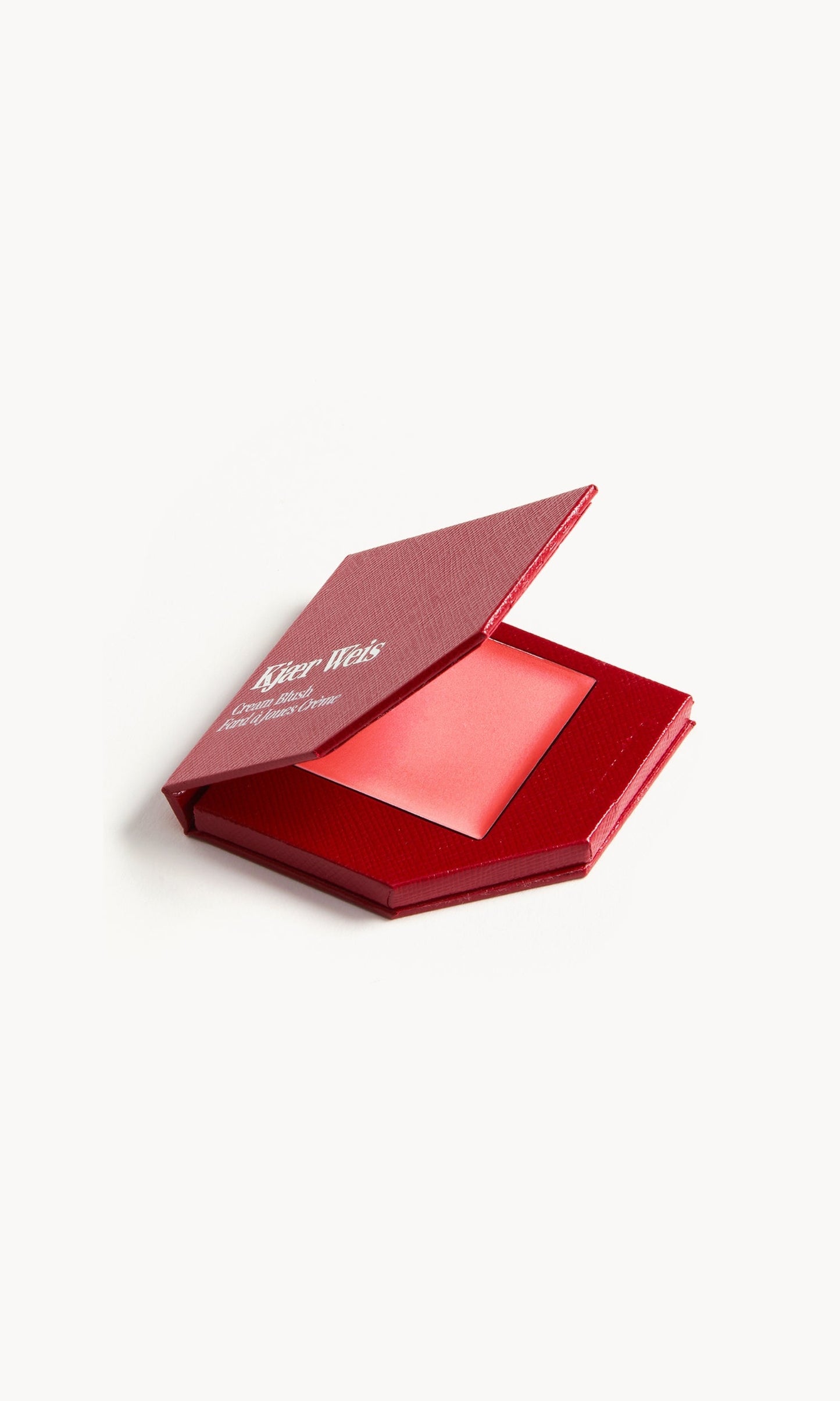 A red KW palette with the lid open to show the cream blush