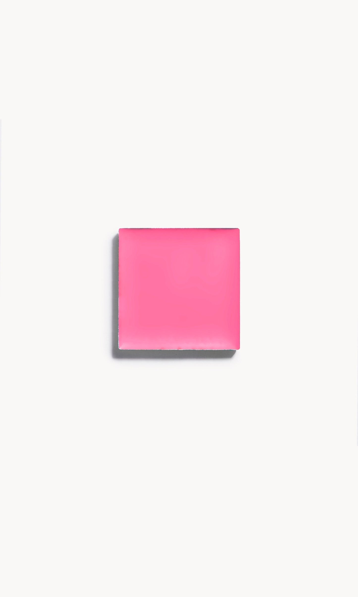 A square of vibrant pink cream blush on a white background