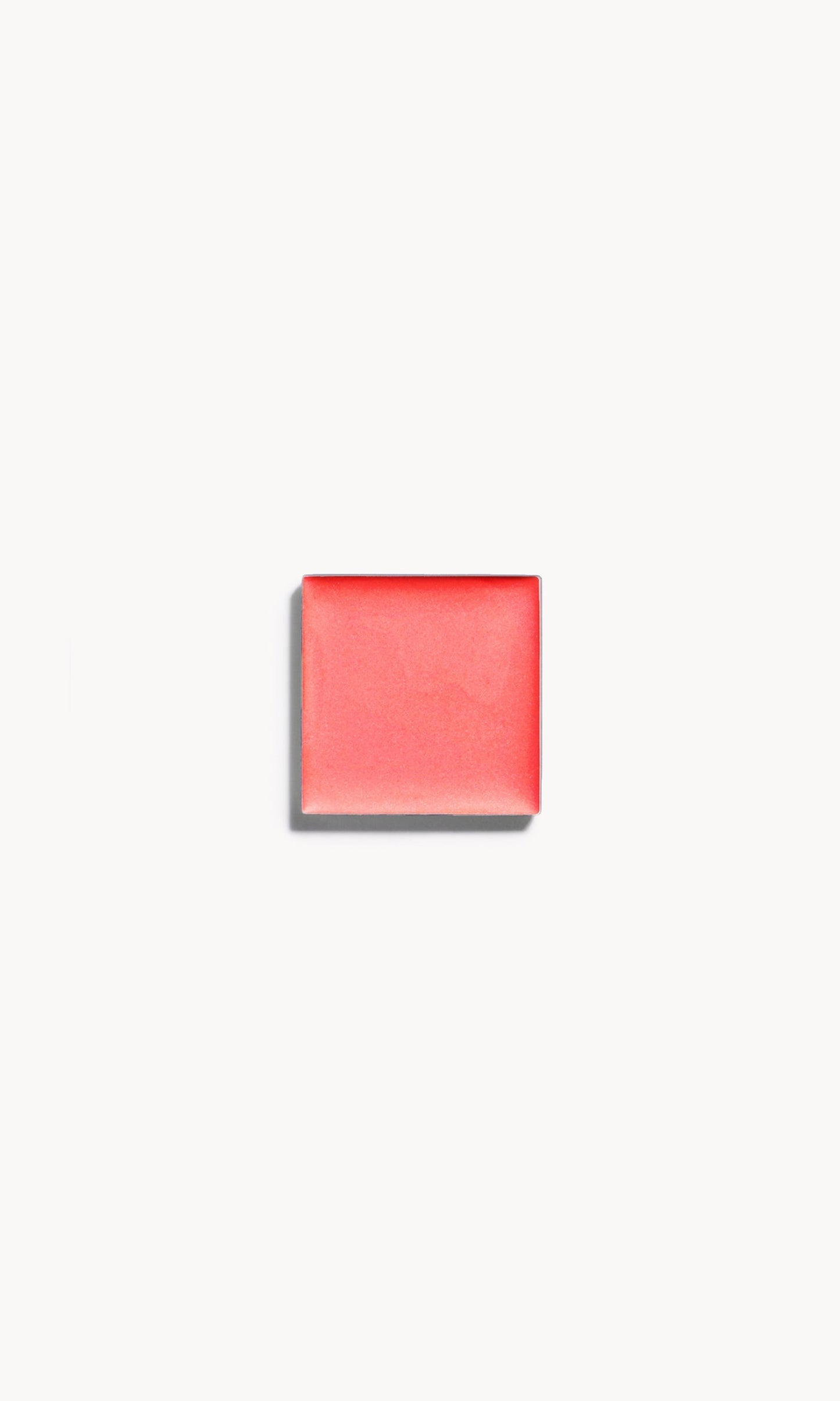 A square of warm coral cream blush on a white background