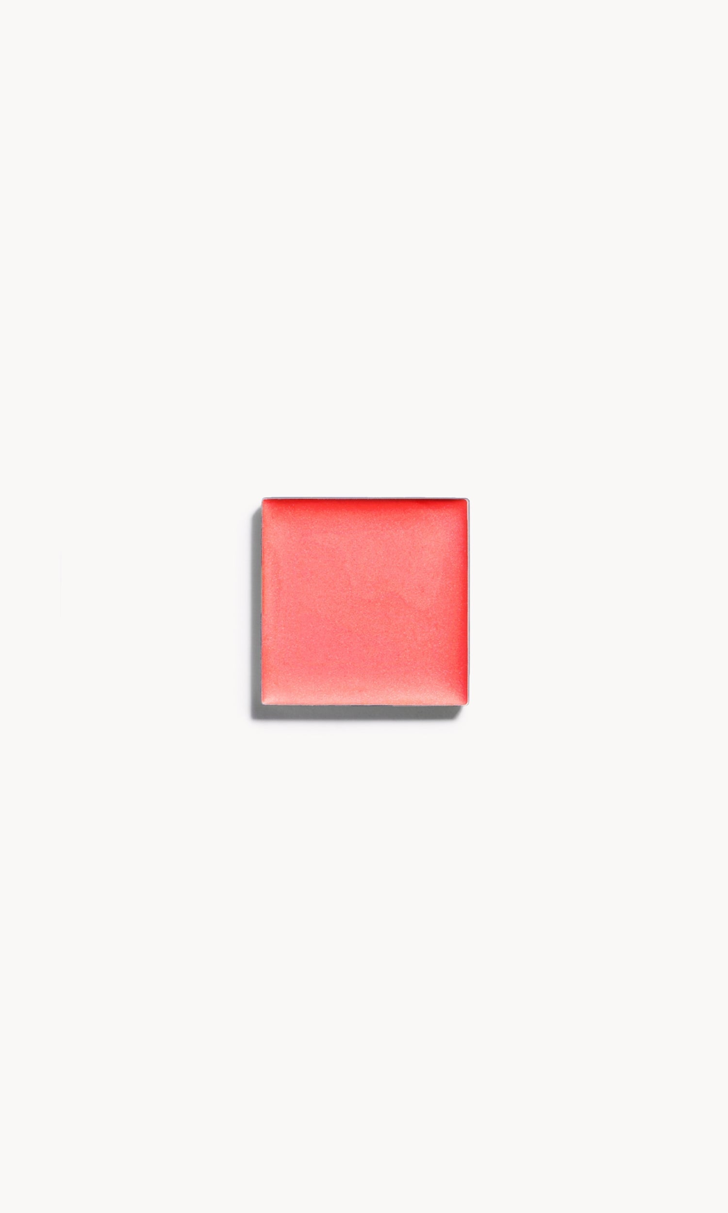 a square of warm coral cream blush on a white background