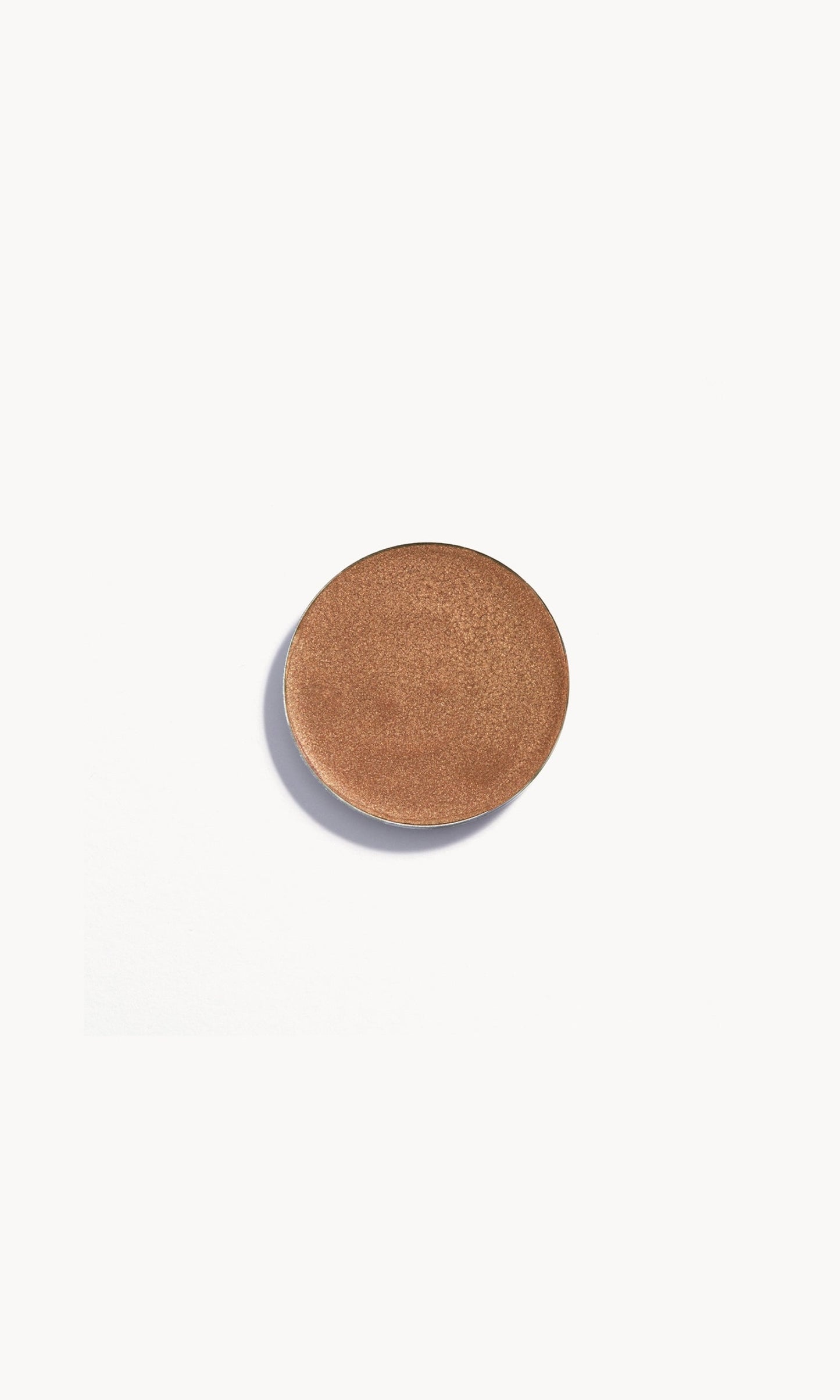 Circle of shimmery medium-gold cream eye shadow on white background