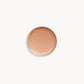 Circle of iridescent peach gold cream eye shadow on white background