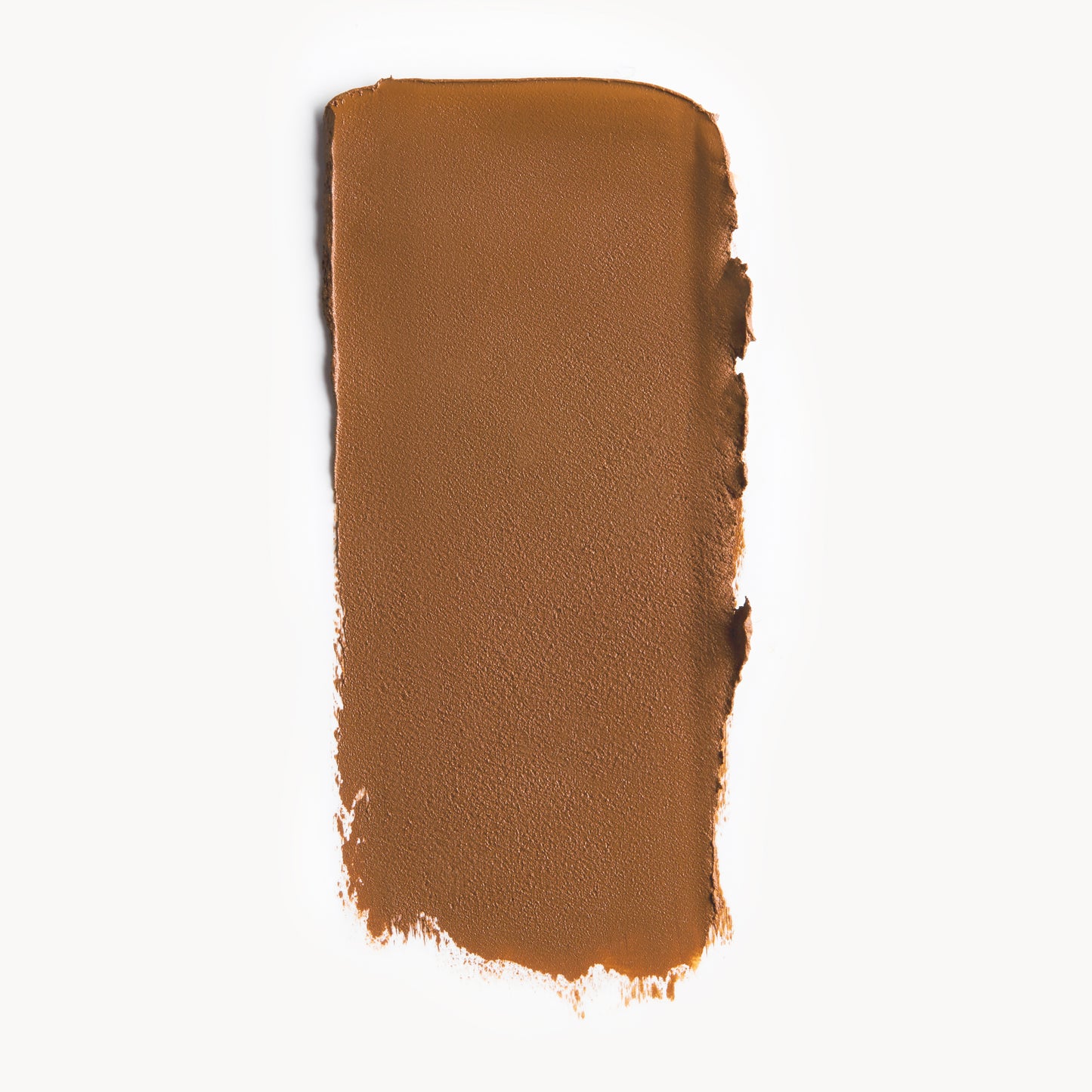 A wipe of warm tan cream foundation on a white background