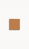 Square of warm tan cream foundation on a white background