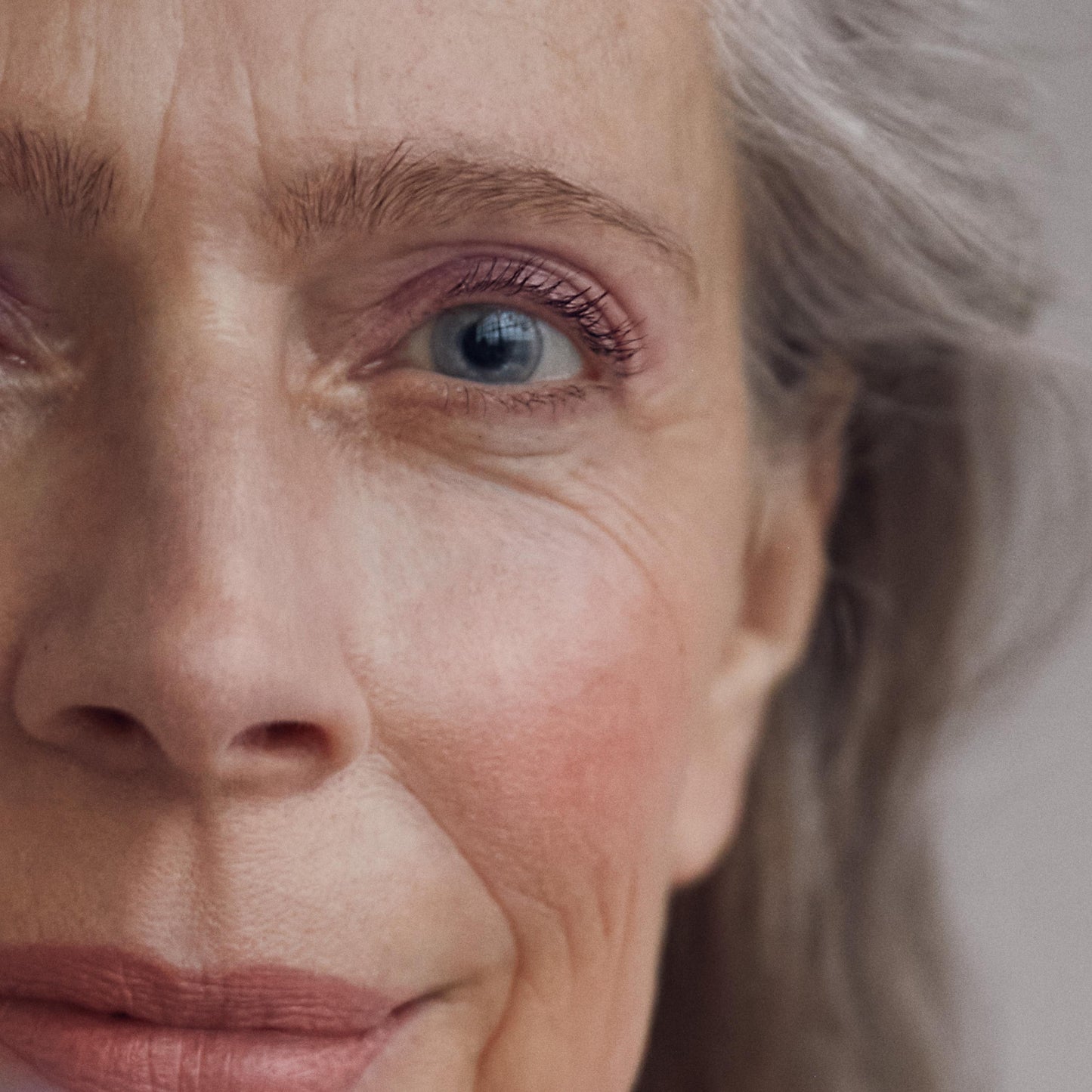 Close up of a person’s face wearing a pink blush