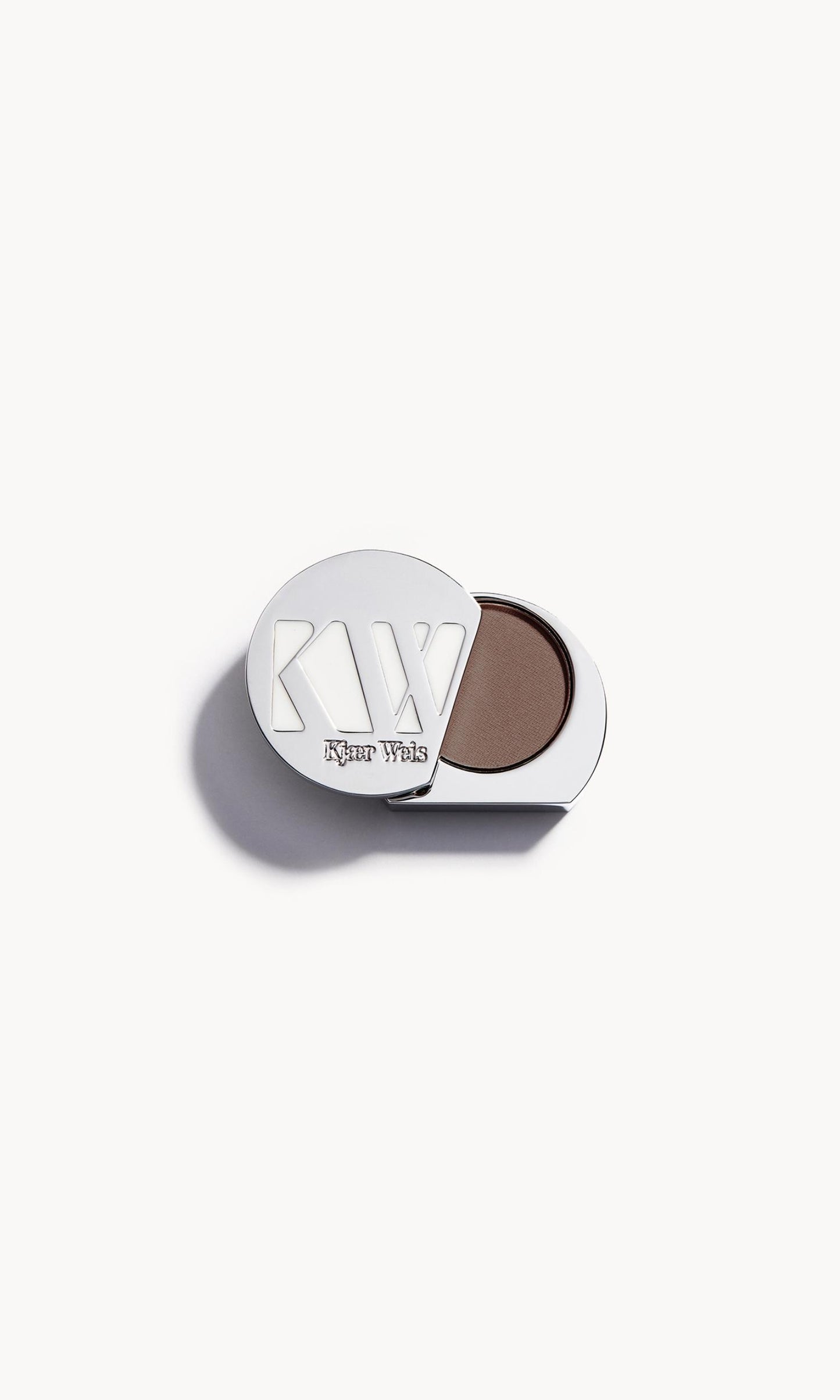 Solid metal KW palette with lid open to show greyish brown eye shadow inside