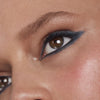 Close up of a person’s eye wearing sea blue eyeliner in a wing shape