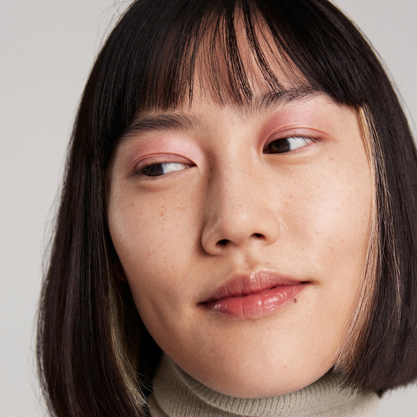 Close up of a person’s face wearing light pink eye shadow