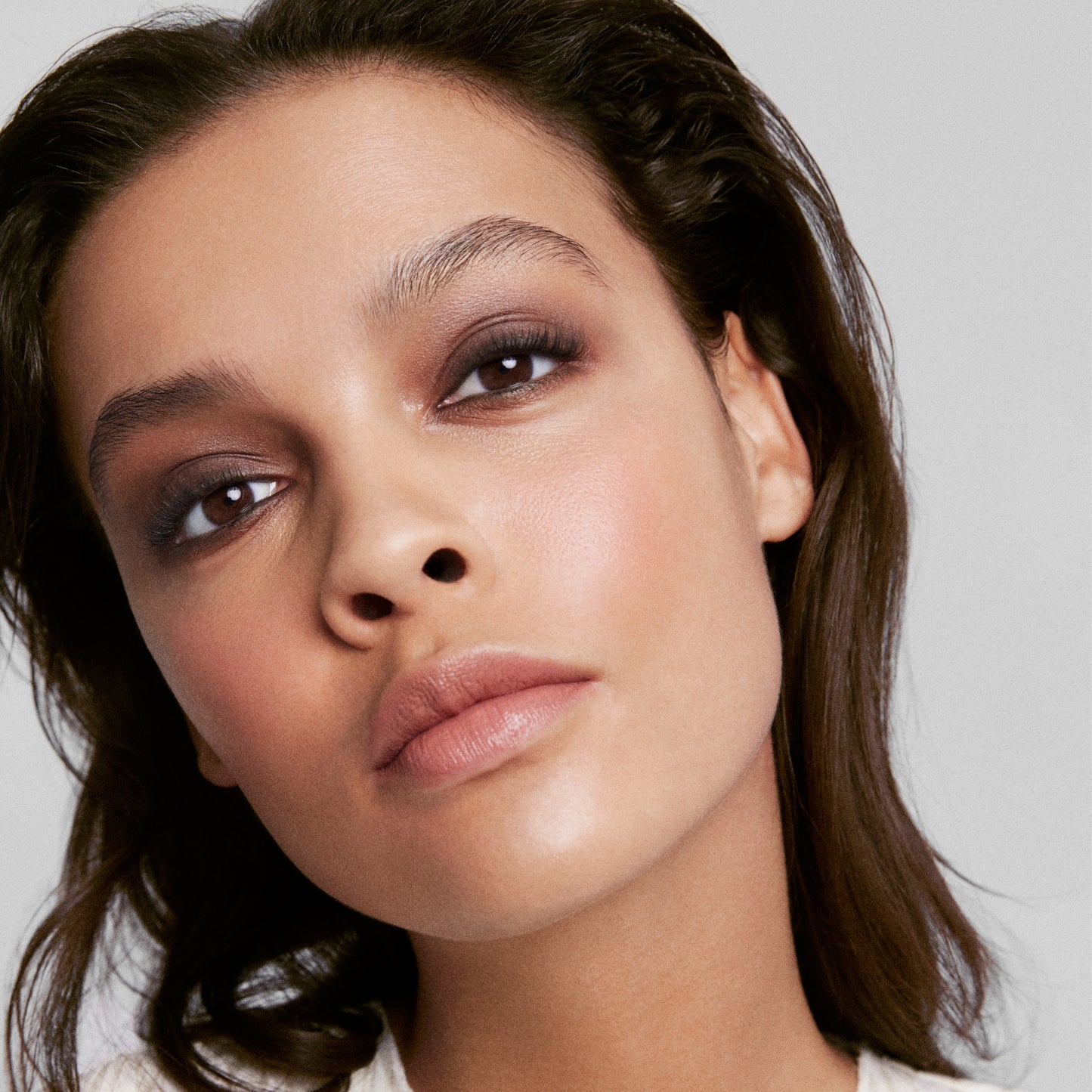 Close up of a person’s face wearing a grey, brown and gold smokey eye shadow look