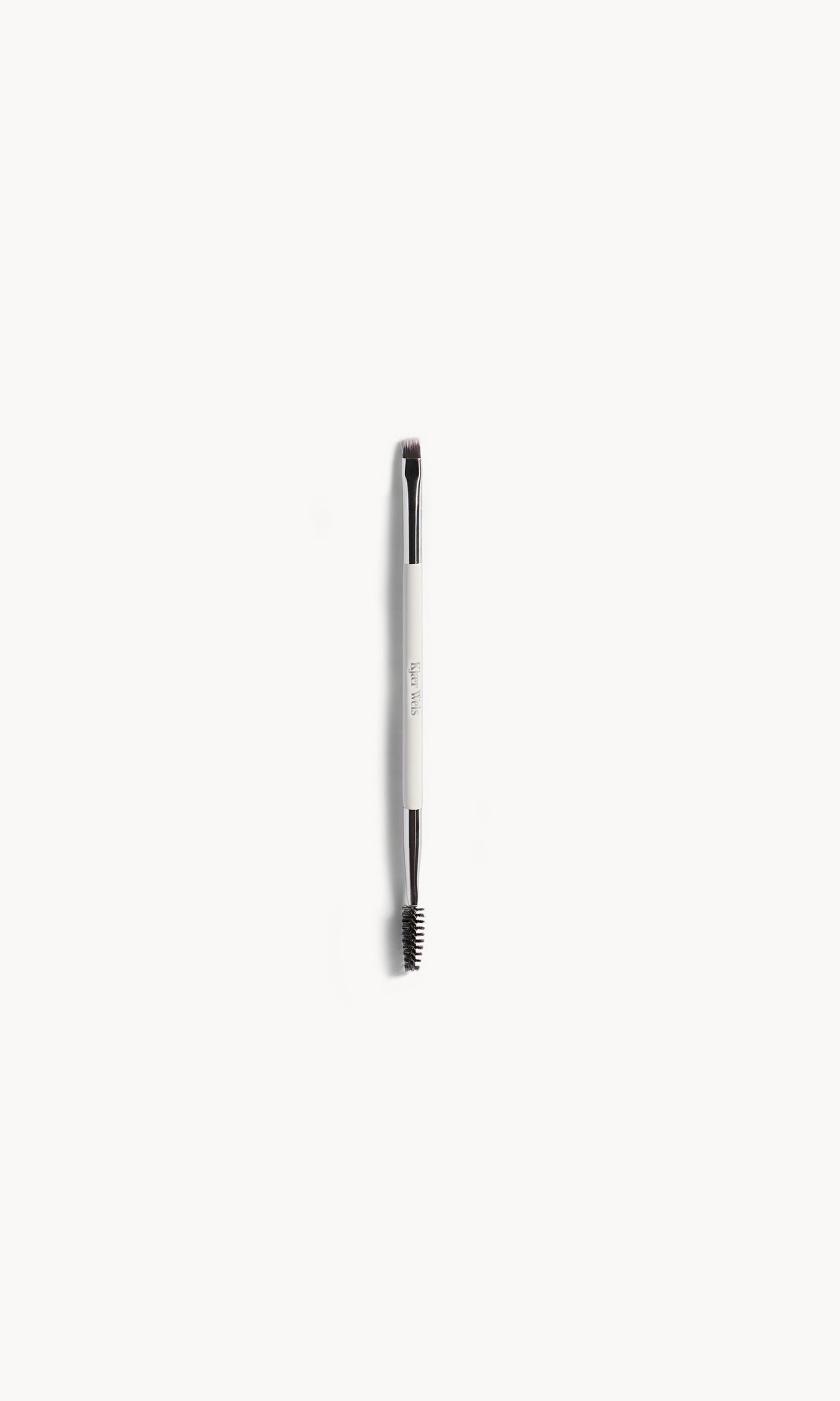 Brush with white and silver handle. One end has a black spoolie and the other end has short brown bristles