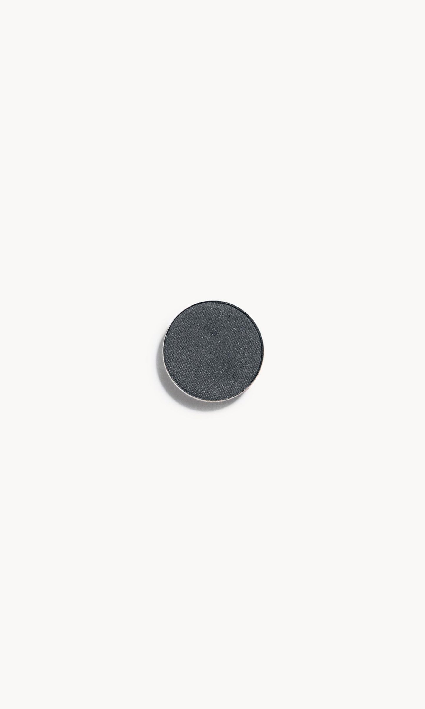 A circle of dark grey eye shadow on a white background