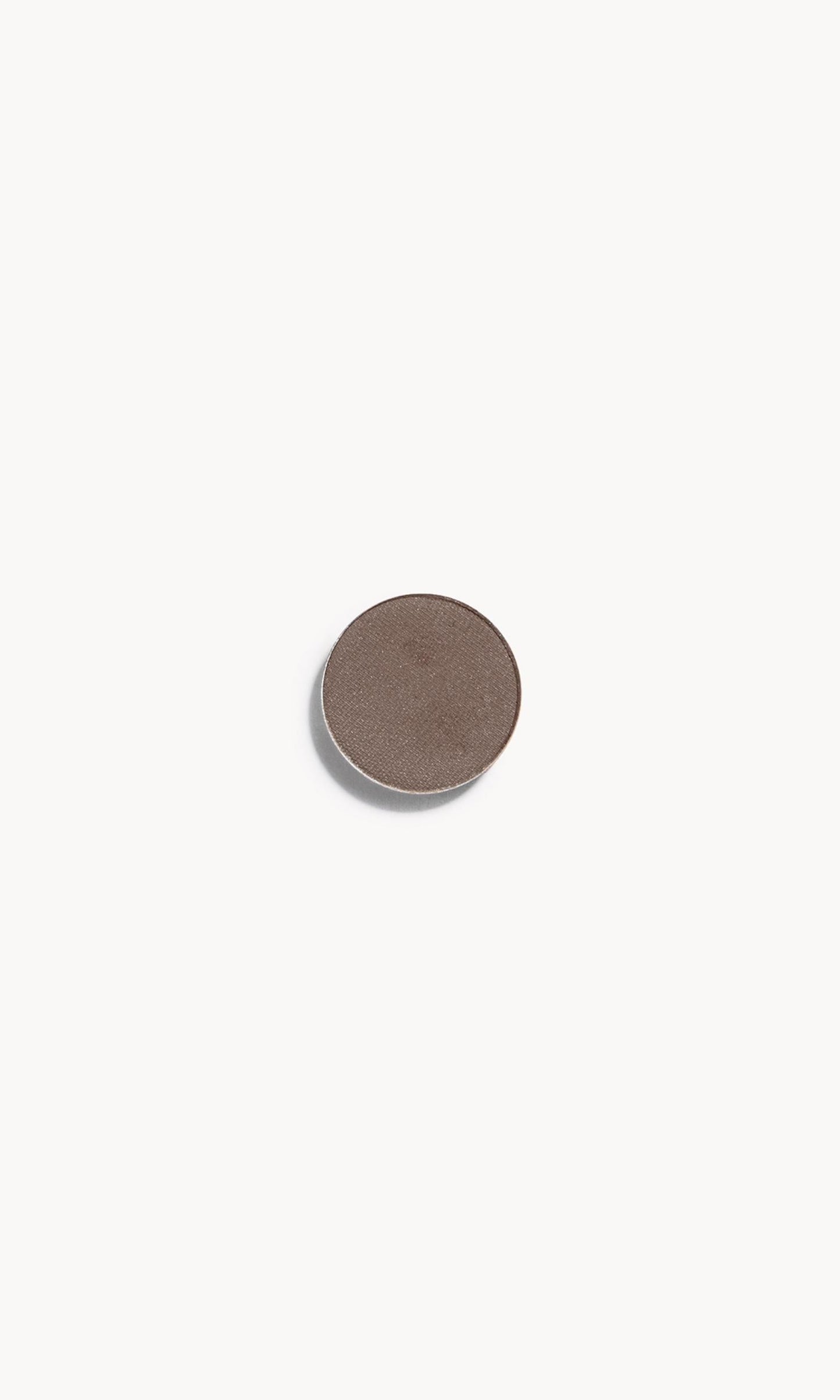 A circle of greyish brown eye shadow on a white background