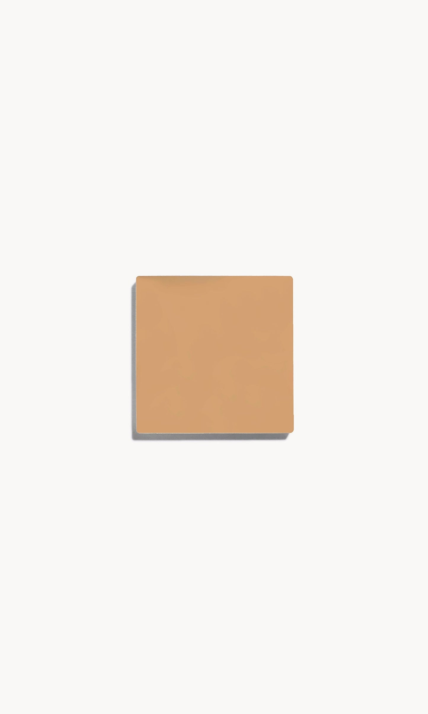 Square of medium warm-toned cream foundation on a white background