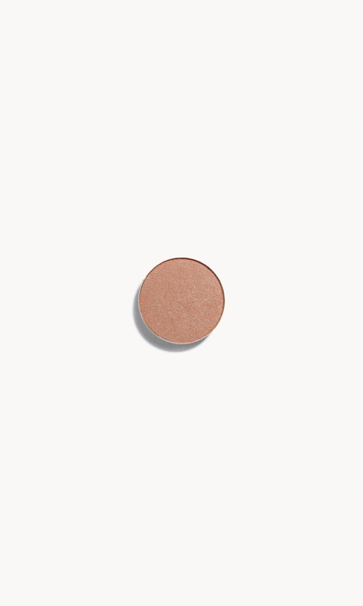 A circle of iridescent champagne pink eye shadow on a white background