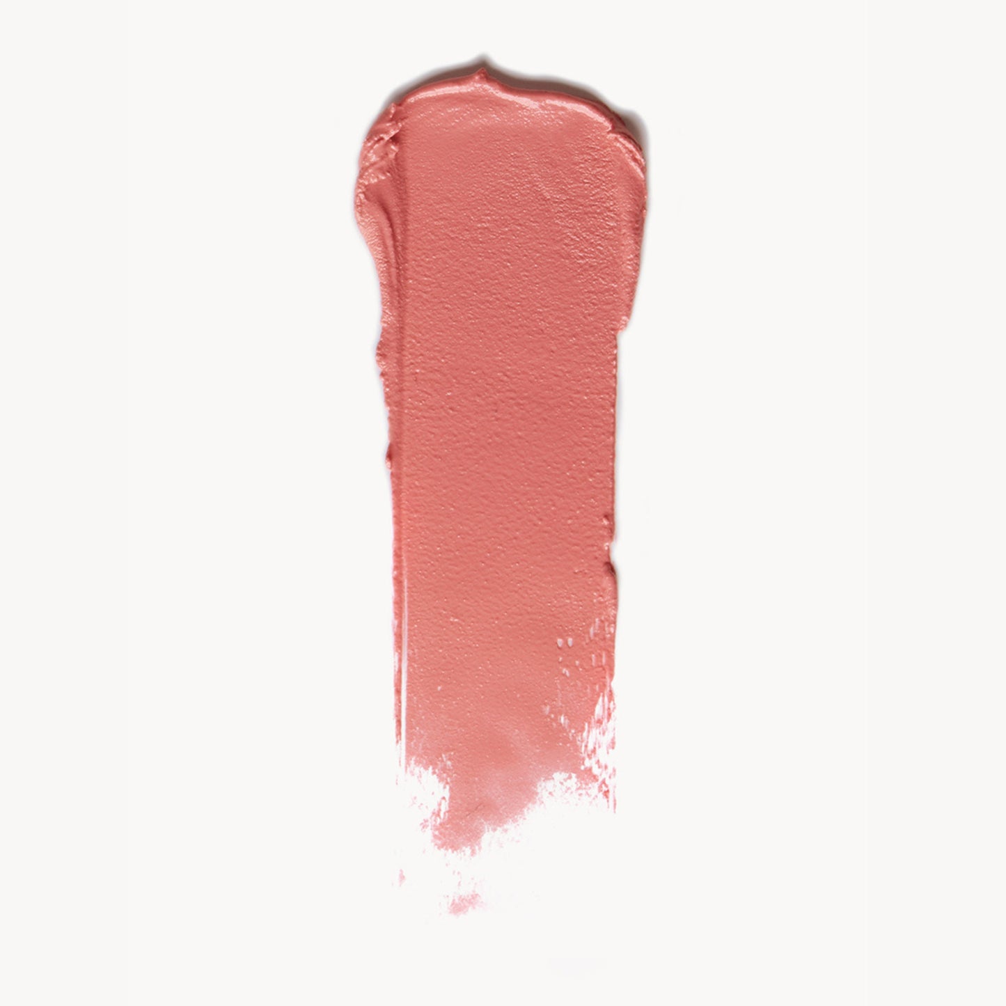 A wipe of soft coral cream blush on a white background