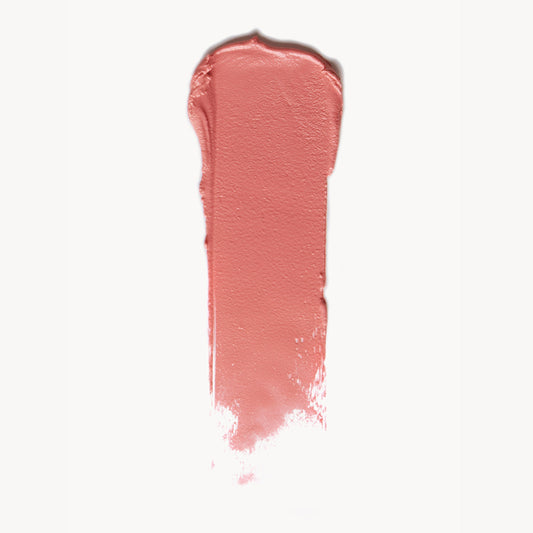 a wipe of soft coral cream blush on a white background
