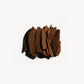 Crumbled up metallic reddish-brown copper eye shadow on a white background