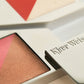 Close up of a flush and glow palette, with Kjaer Weis embossed on the metal packaging 