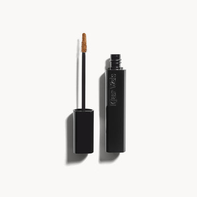 Kjaer Weis The Brow Gel in Blonde, shown open with its precise, slimline brush applicator on an off-white background.