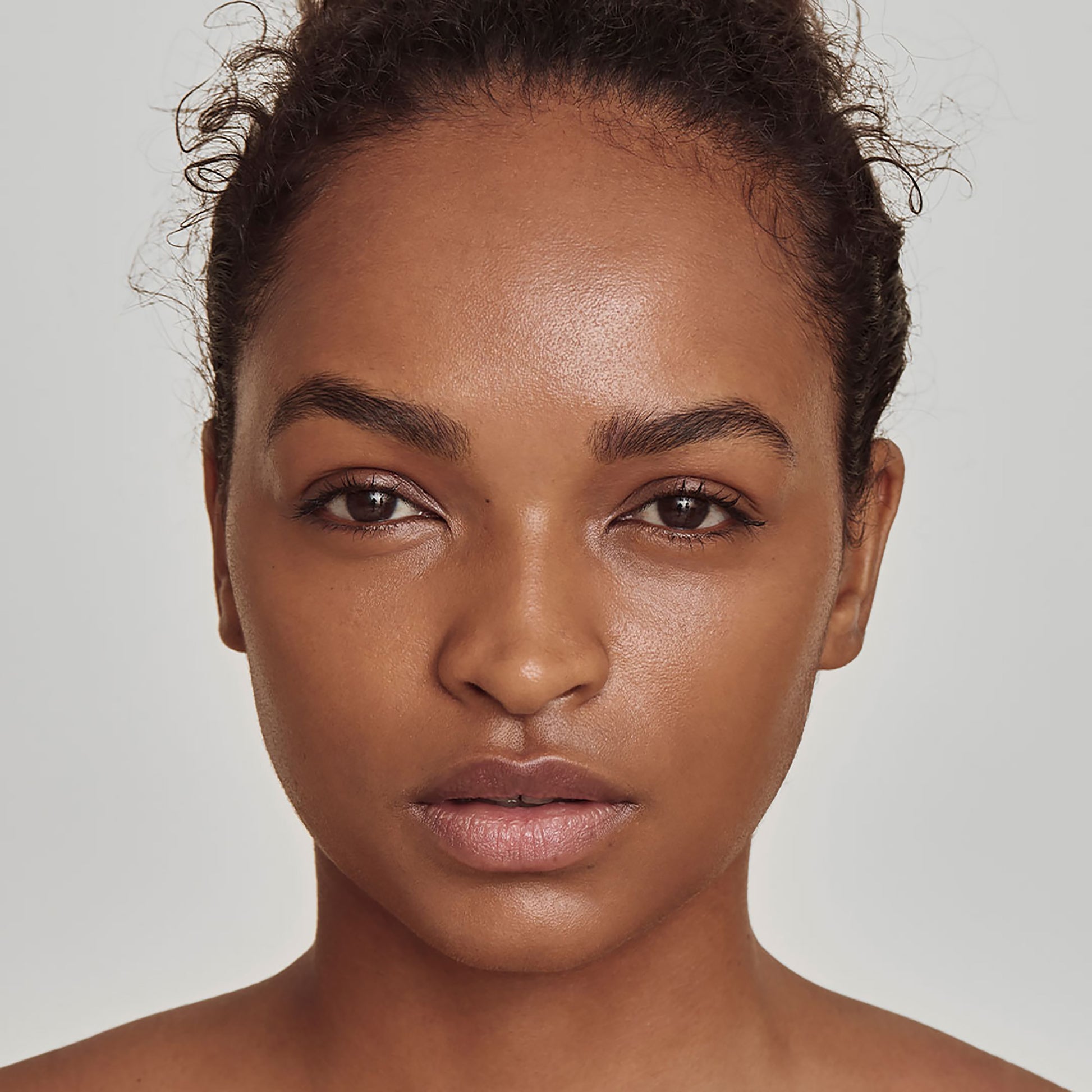 Close up of a person’s face with deep warm-toned skin