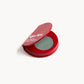 Red KW palette open to show the green eye shadow with gold flecks inside