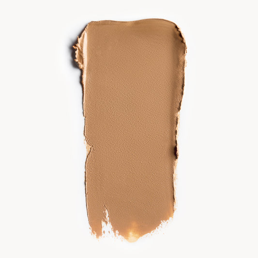 a wipe of medium, warm-toned cream foundation on a white background