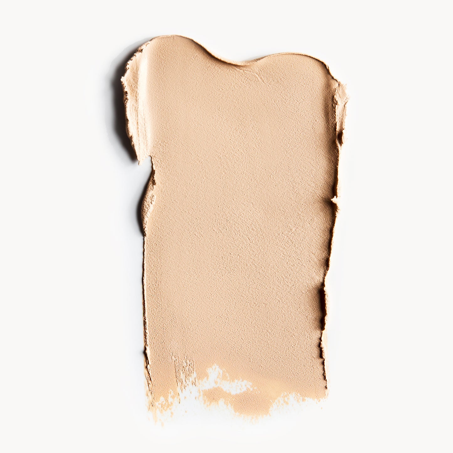 A wipe of fair, neutral-toned cream foundation on a white background