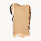 A wipe of light, warm-toned cream foundation on a white background