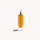 Glass bottle with white pipette top and gold-coloured liquid inside on a white background
