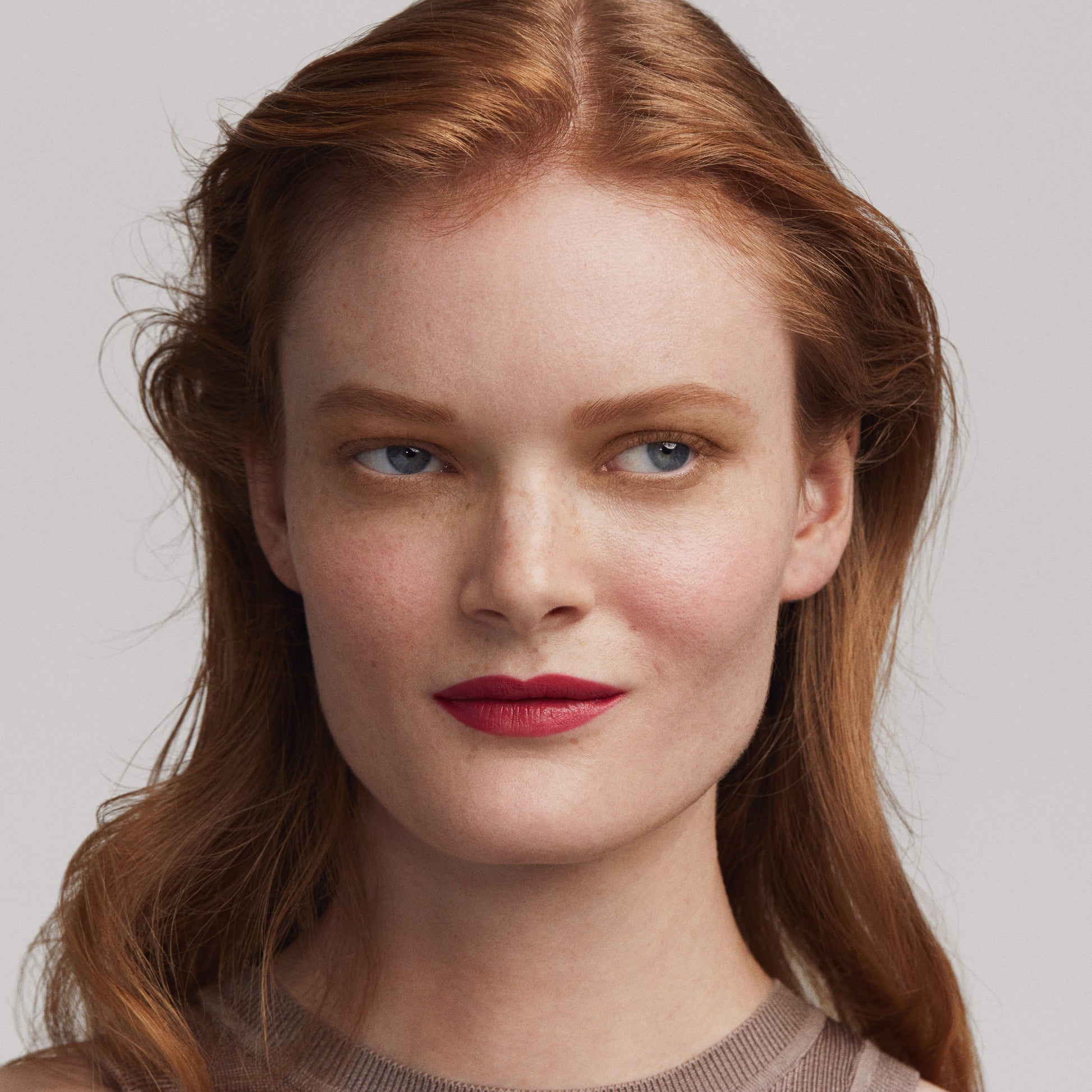 woman with red hair and fair skin wearing kjaer weis brow gel in blonde shade