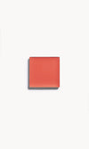 A square of warm coral cream blush on a white background