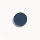 Circle of deep blue cream eye shadow on white background