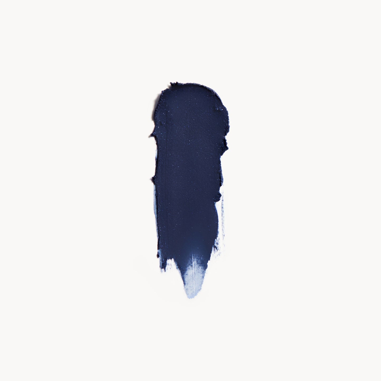 A wipe of deep blue cream eye shadow on a white background