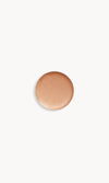 Circle of iridescent peach gold cream eye shadow on white background