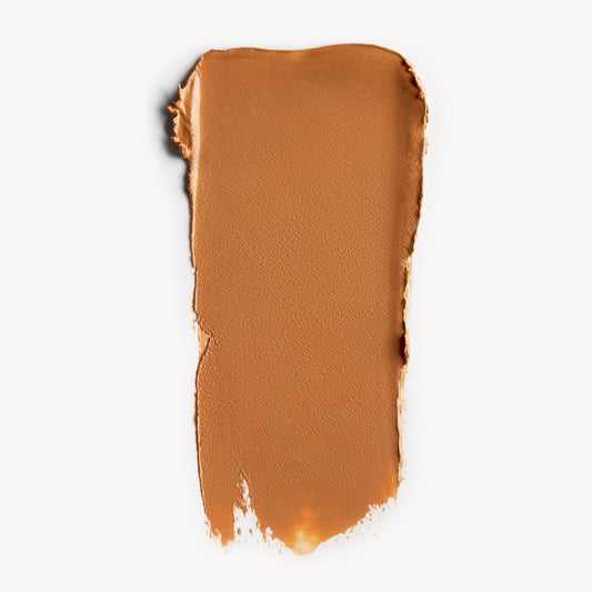 a wipe of warm tan cream foundation on a white background