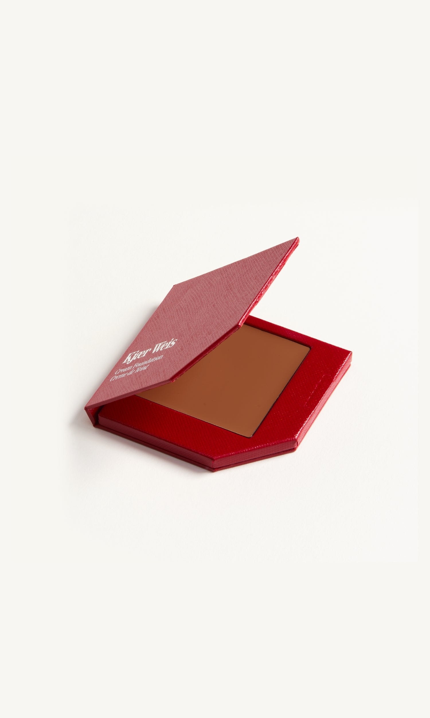 red kw palette with lid open to show cream foundation 