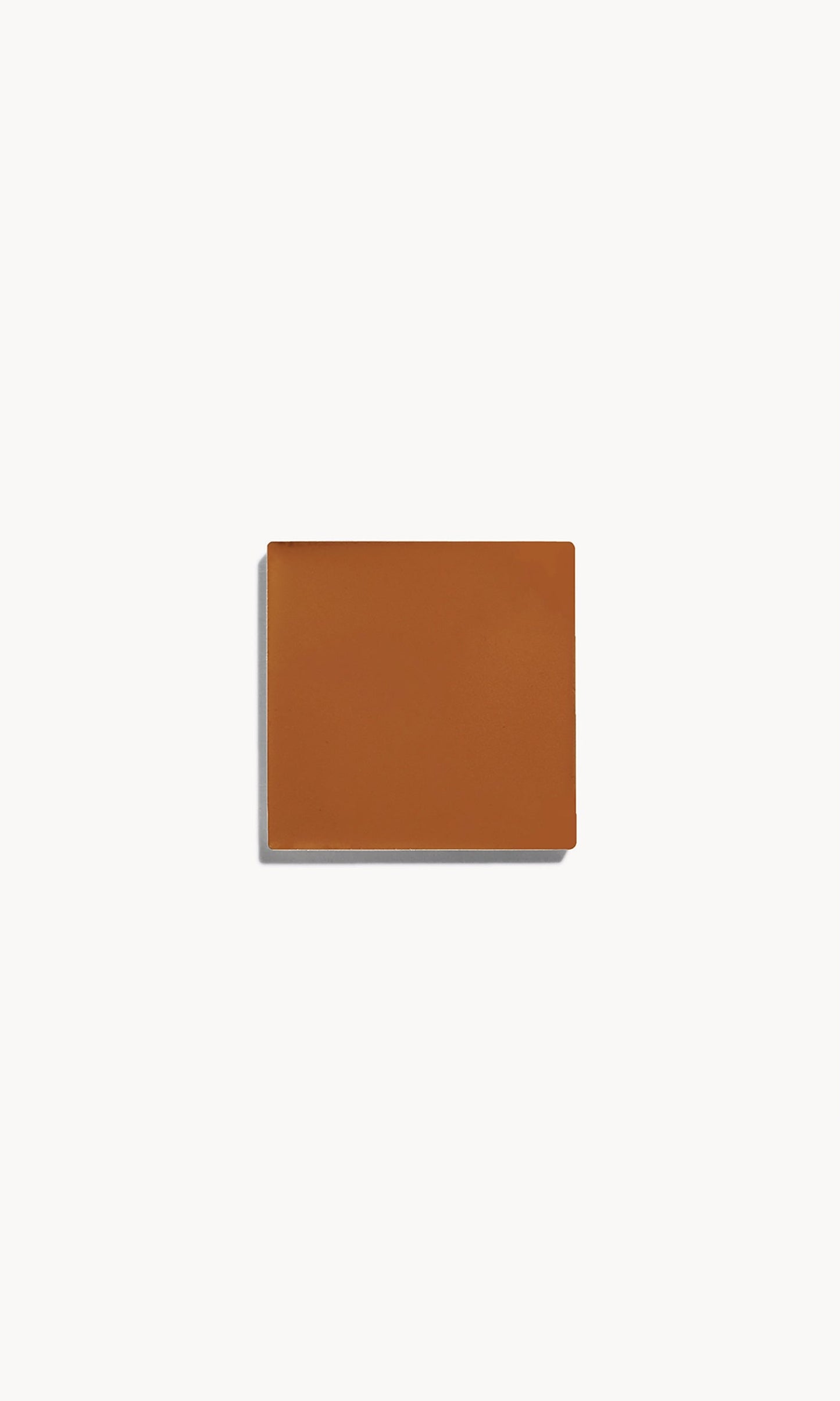 Square of deep warm cream foundation on a white background
