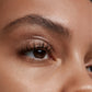 Close up of person’s eye with a medium skin tone wearing cream eye shadow