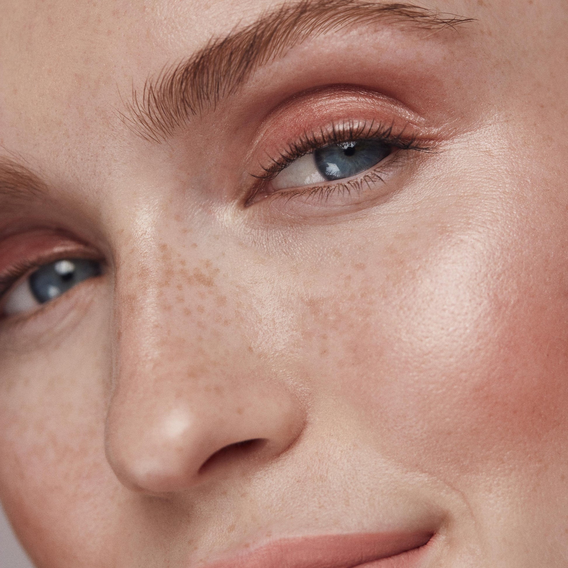 Close up of a person’s face with a fair skin tone wearing cream highlighter 