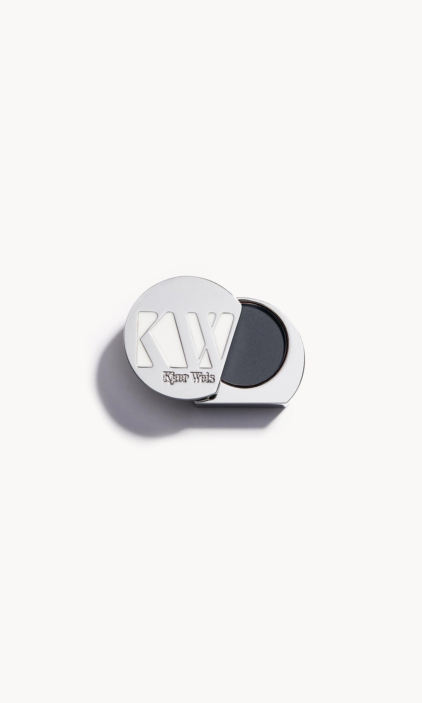Solid metal KW palette with lid open to show dark neutral grey eye shadow inside