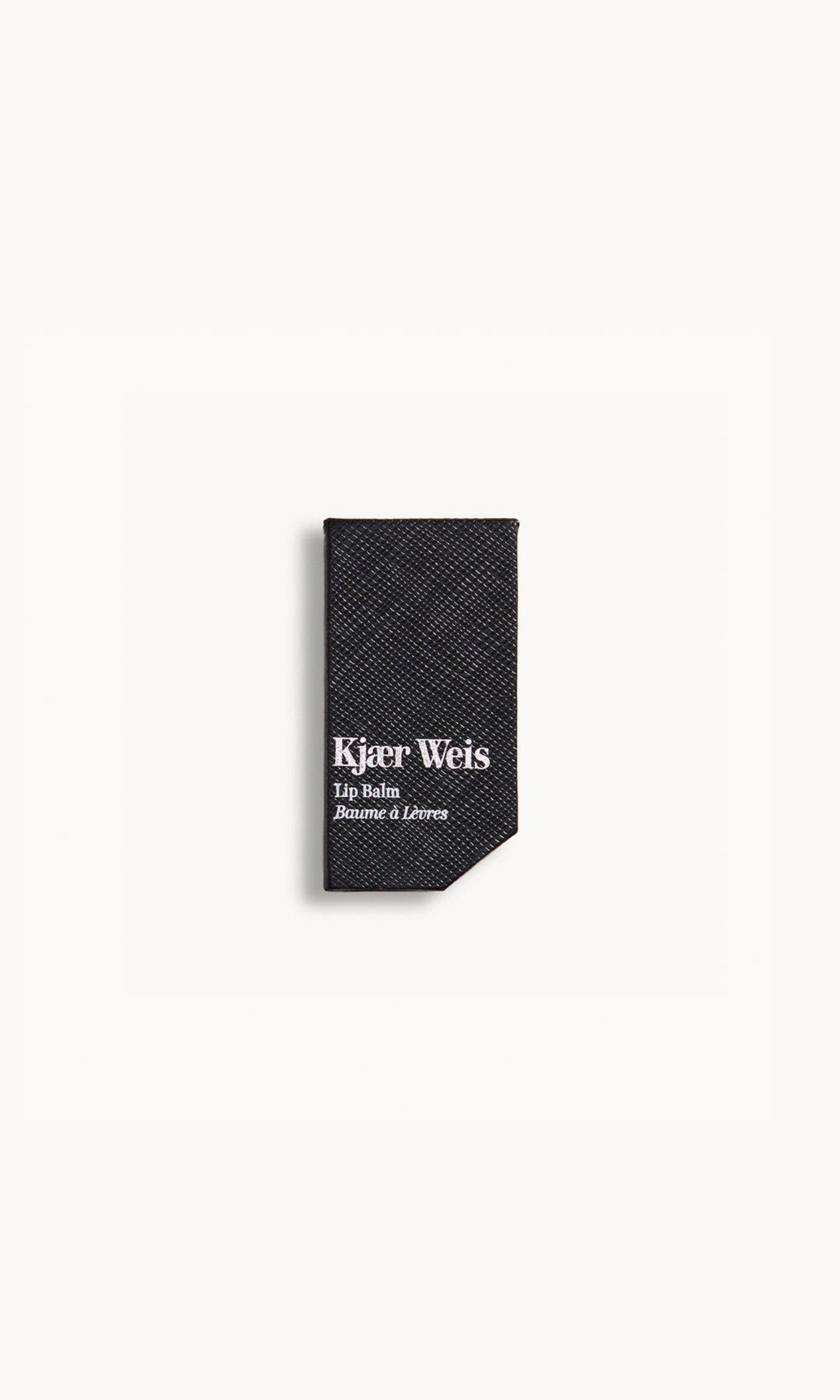 Kjaer Weis lip balm packaging in black textured paper